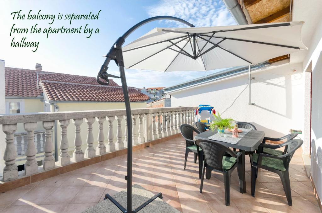 a patio with a table and an umbrella on a balcony at Apartment Marija in Vodice