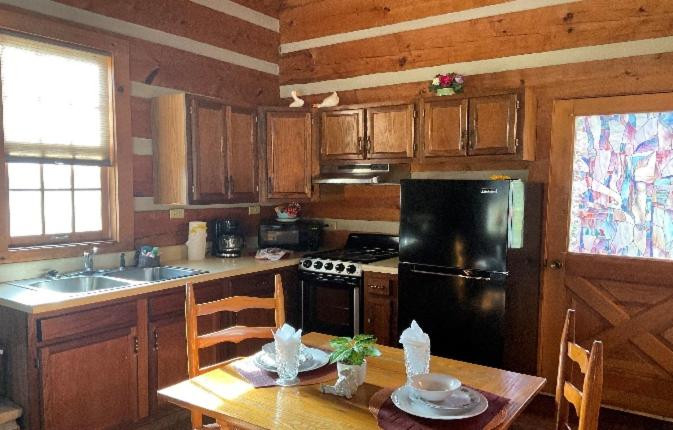 a kitchen with a table and a black refrigerator at Lover's Leap in Sevierville