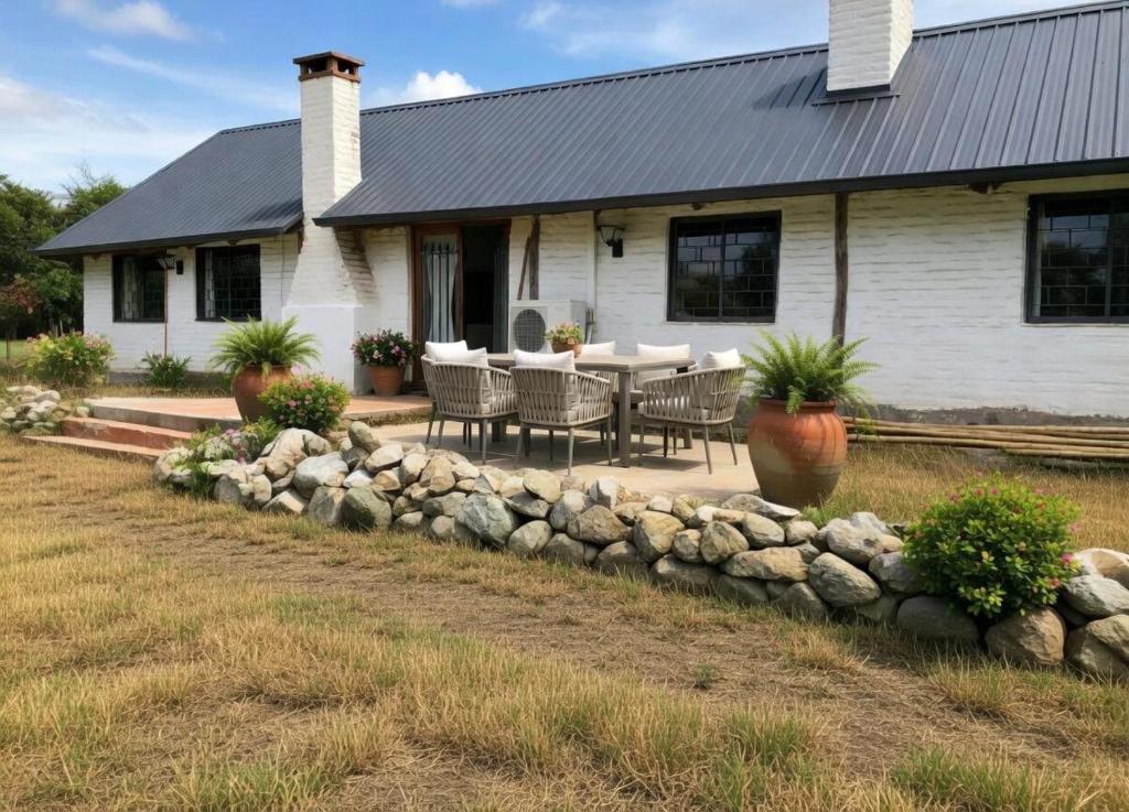 a house with a table and chairs in front of it at Atahualpa Yupanqui 2 in Tafí del Valle