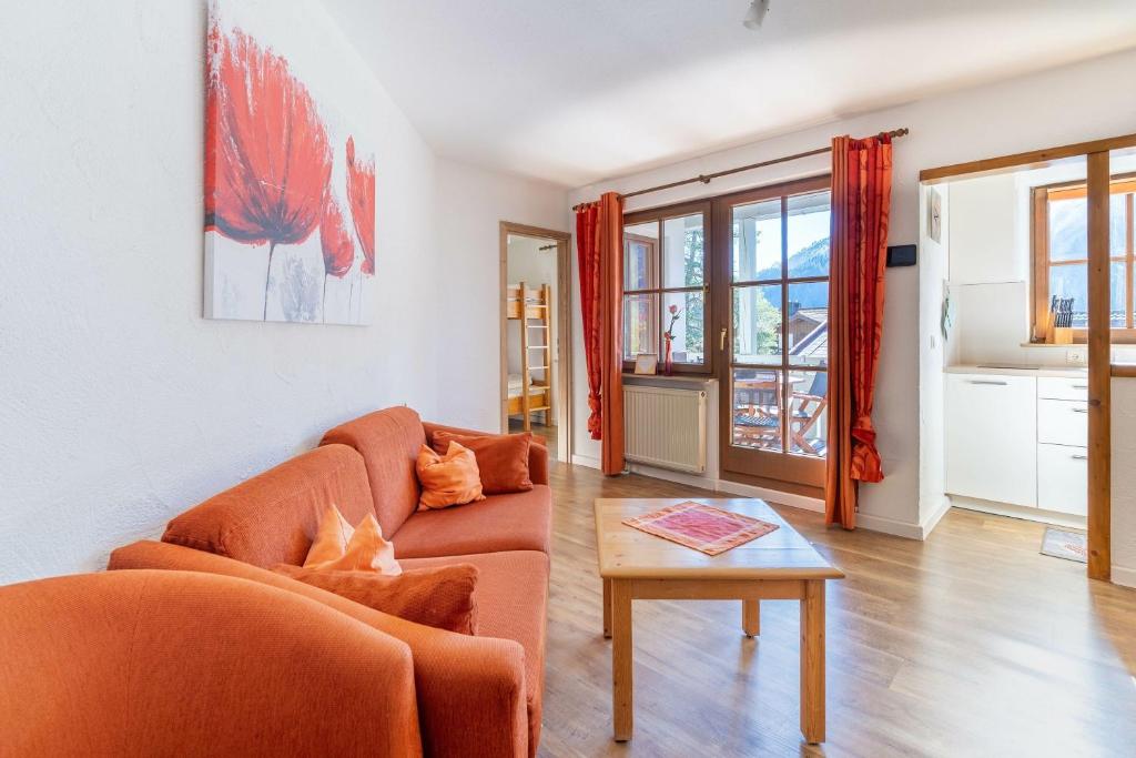 a living room with two orange couches and a table at Sonnenschein in Bad Hindelang