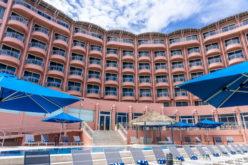a large building with blue umbrellas in front of it at Grand Hotel & Casino in Port Vila