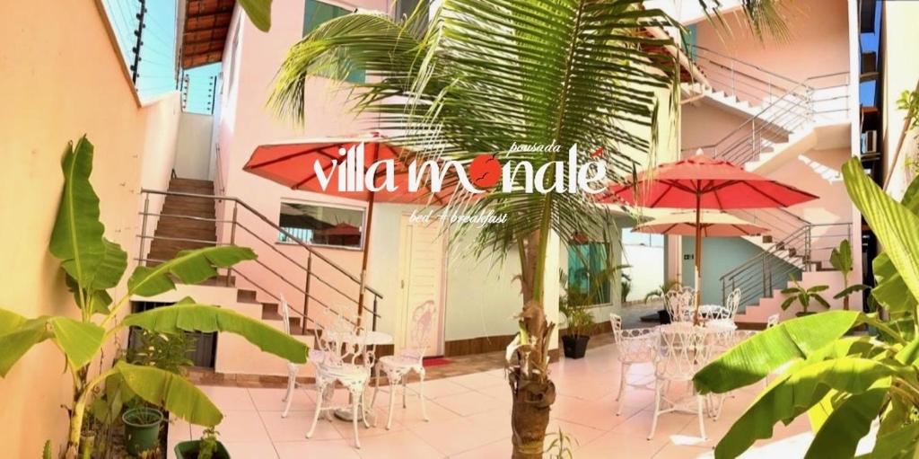 a restaurant with a table and chairs and umbrellas at Pousada Villa Monale in Barreirinhas