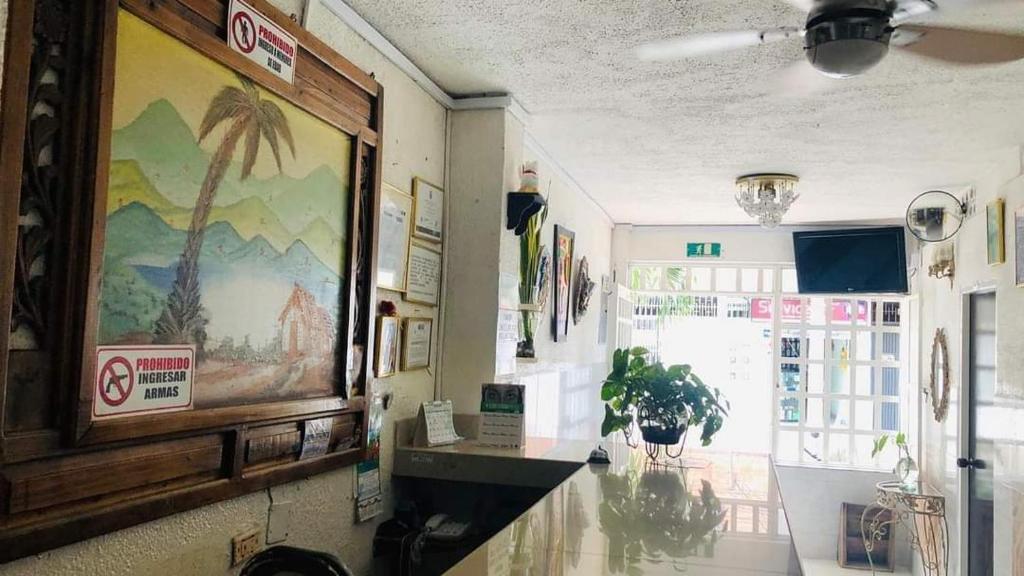 a room with a painting of a palm tree on the wall at Hotel La Palma Girardot in Girardot