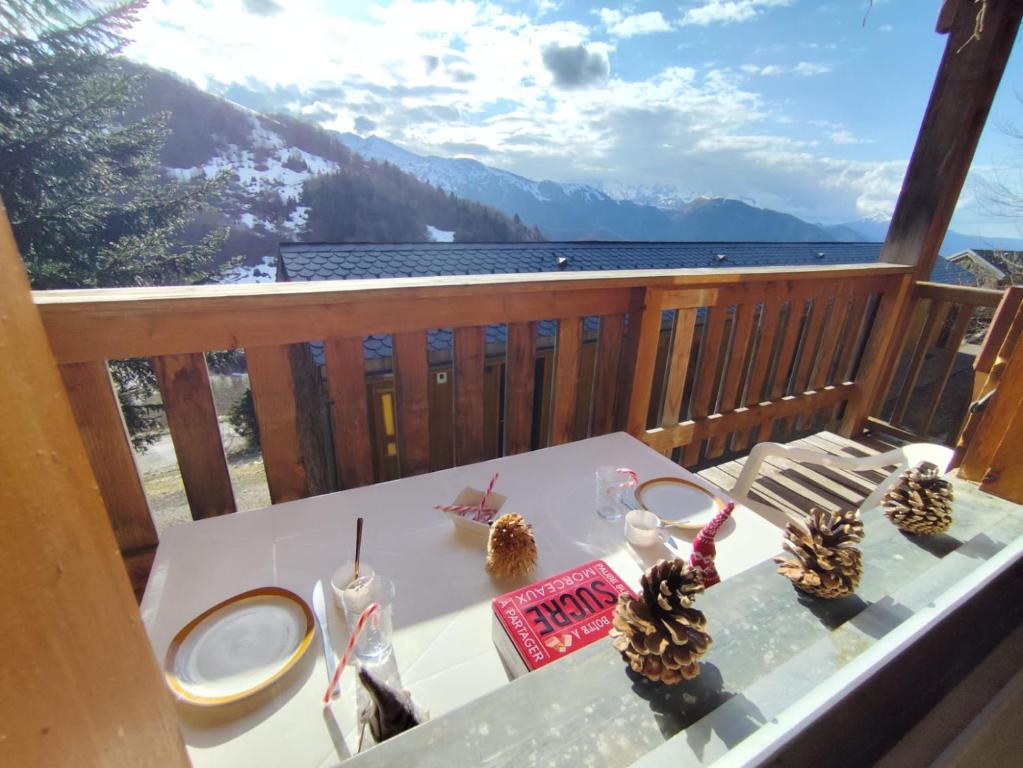 a table on a balcony with a view of the mountains at Le Doux Refuge in Ustou