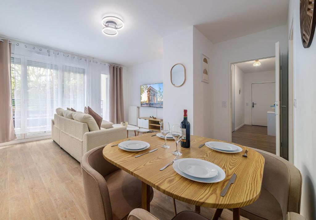a dining room and living room with a wooden table at 2 Bedroom Apartment for 6 with Private Parking - Elevator - High-Speed WiFi in Champigny-sur-Marne