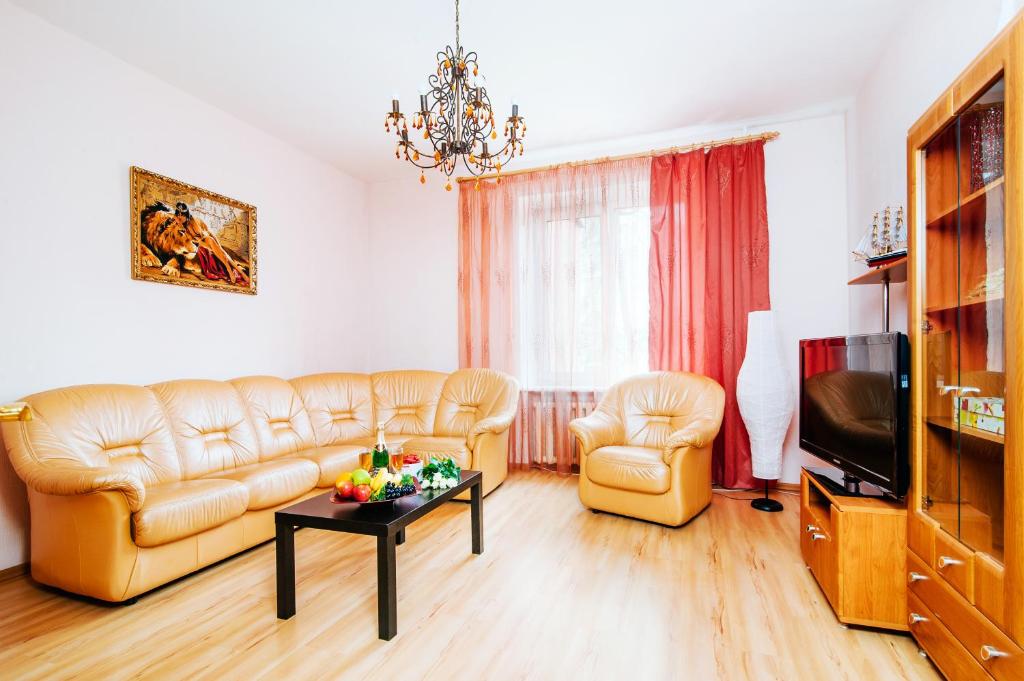 a living room with leather couches and a television at Kozlov 9 Victory Square in Minsk