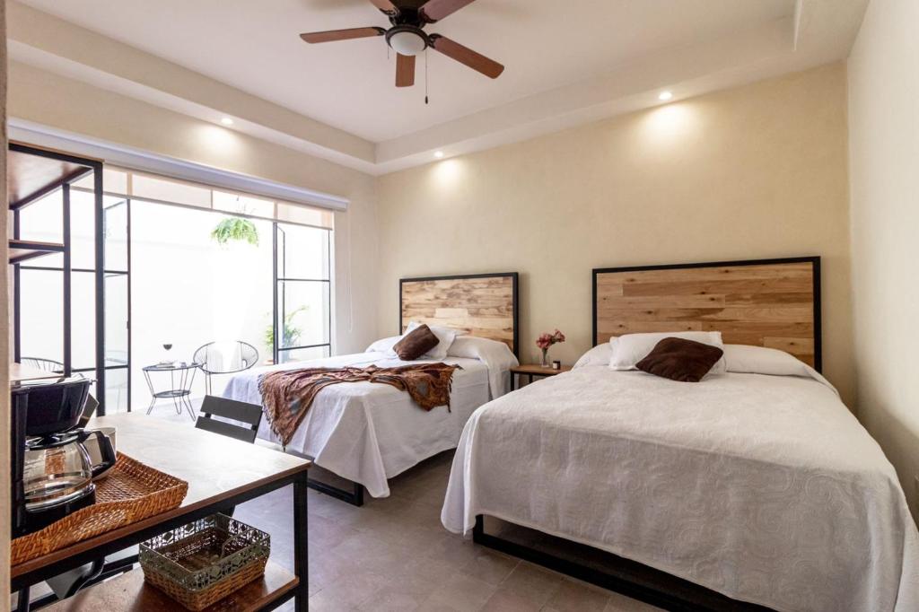 a bedroom with two beds and a ceiling fan at Casa María Teresa Suites in León