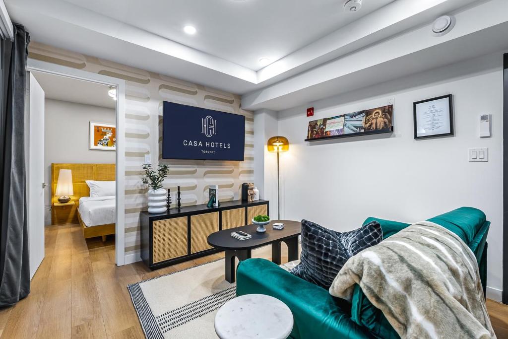 a living room with a green couch and a bed at The McCaul by Casa Hotels Near AGO Basement Suite in Toronto