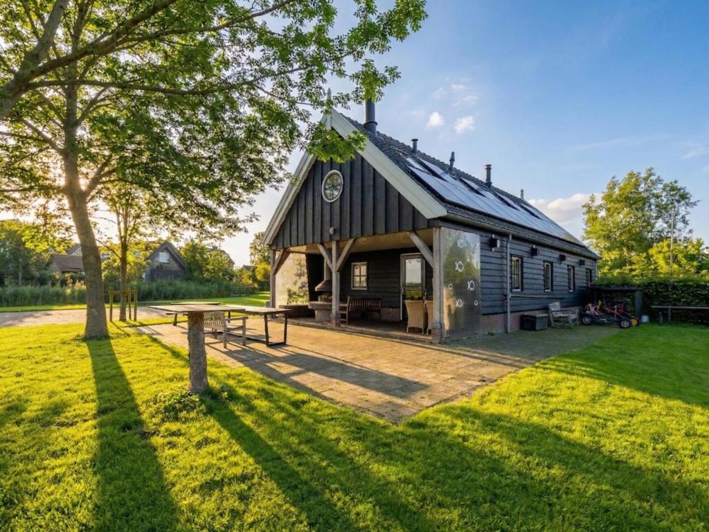 a barn with a picnic table in a yard at De Schuur in Kaag