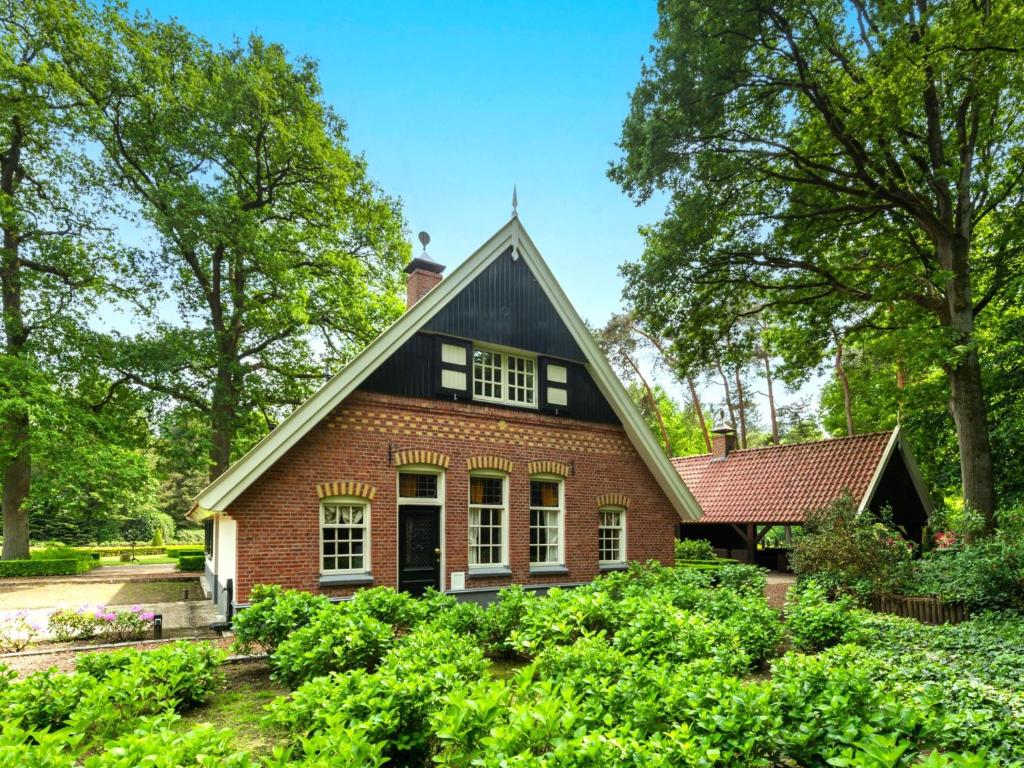 a red brick house with a black roof at Erve Het Klaashuis in Deurningen