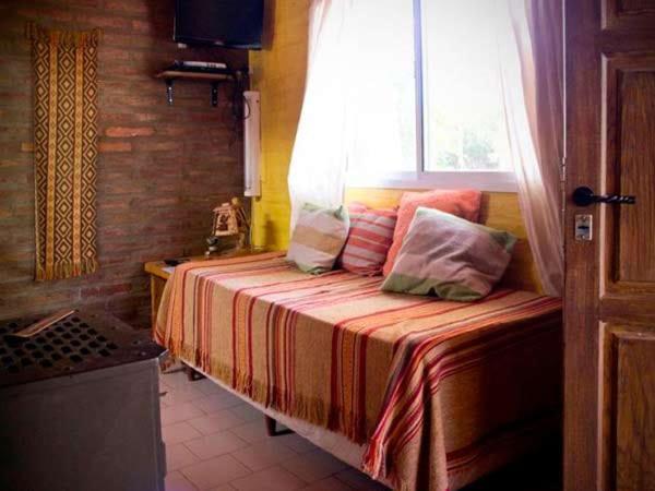 a bedroom with a bed with a window and pillows at Cabañas Blumenhaus in Villa Ventana