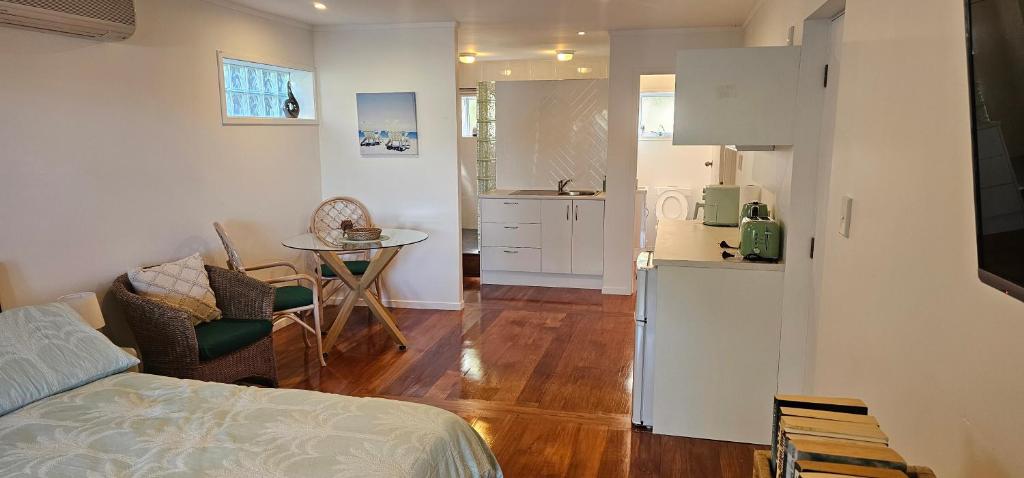 a room with a bed and a table and a kitchen at Mansio Awatere in Snells Beach
