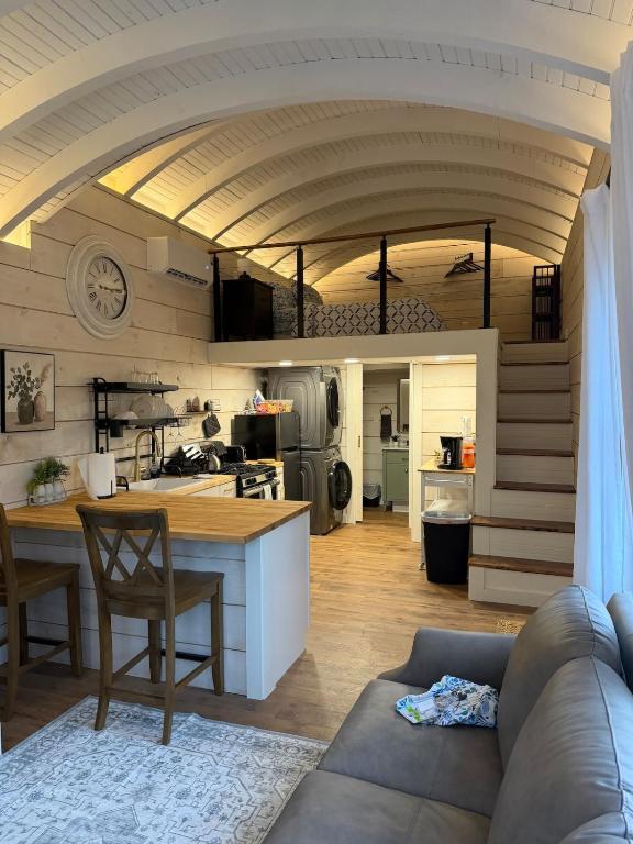 a kitchen and living room with a couch and a table at Backyard Tiny House in the Woods in Tolland