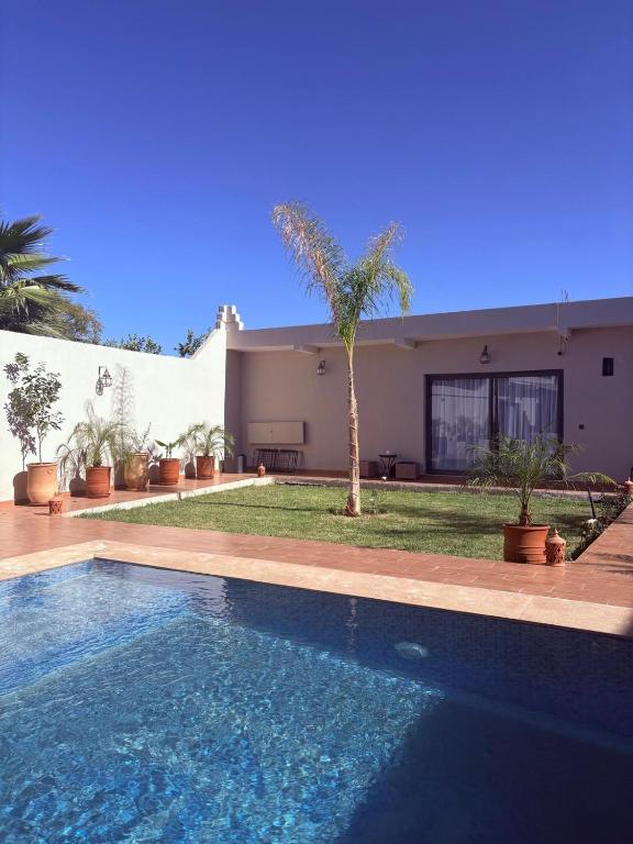 ein Haus mit einem Swimmingpool vor dem Haus in der Unterkunft Dar Timi in Ech Chaïbat
