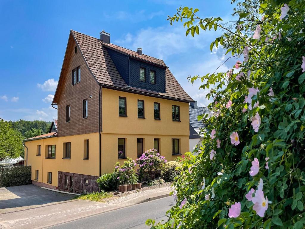 a yellow house with a brown roof at Ferienwohnung im Erholungsort in Kurort Steinbach-Hallenberg