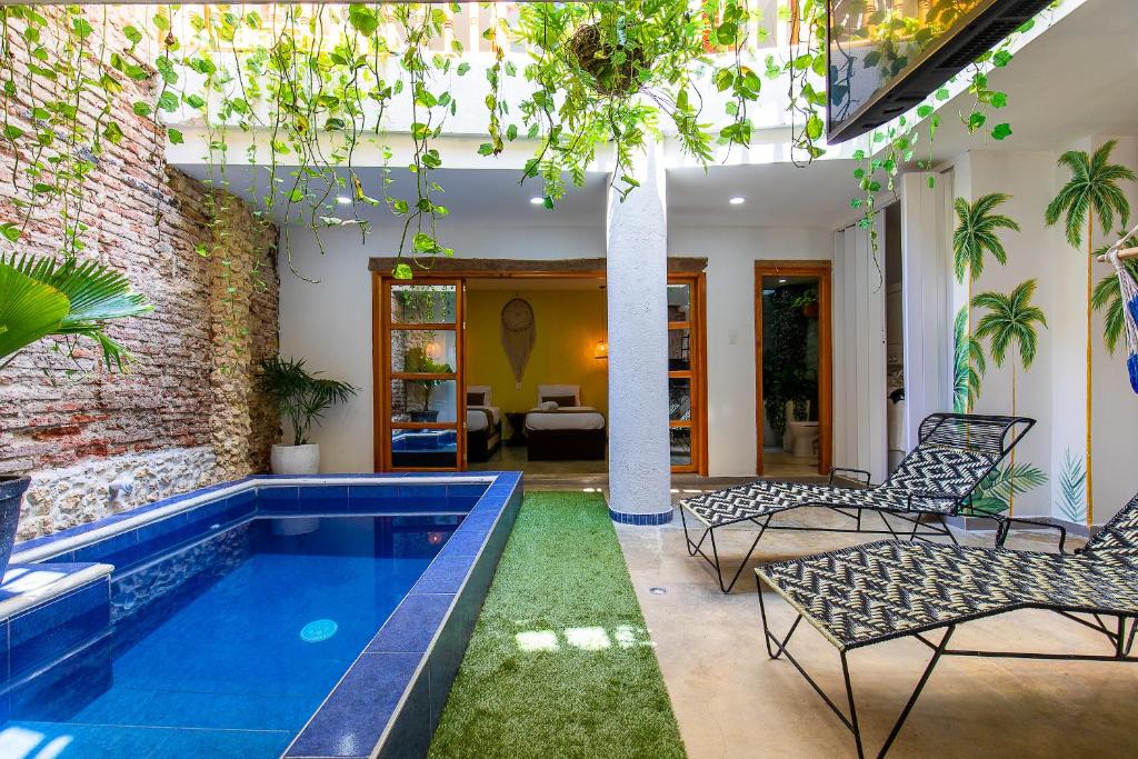 an indoor swimming pool with chairs and a house at House with Private Pool & Rooftop in Cartagena de Indias