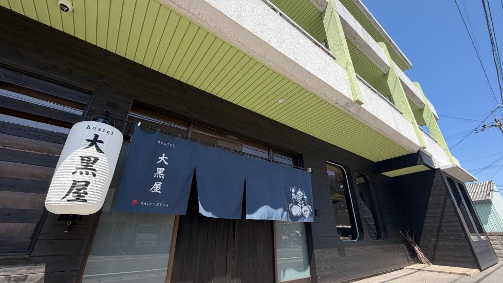 a sign on the side of a building at hostel大黒屋 in Miyoshi