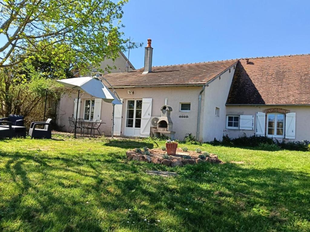 an old white house with a yard with a yard at Gîte campagne et clim - 4 pers. - FR-1-489-84 in Saint-Bonnet-Tronçais