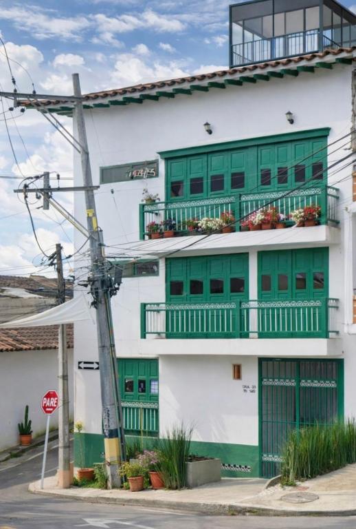 a white building with green windows and a stop sign at Raíz Serena in El Retiro