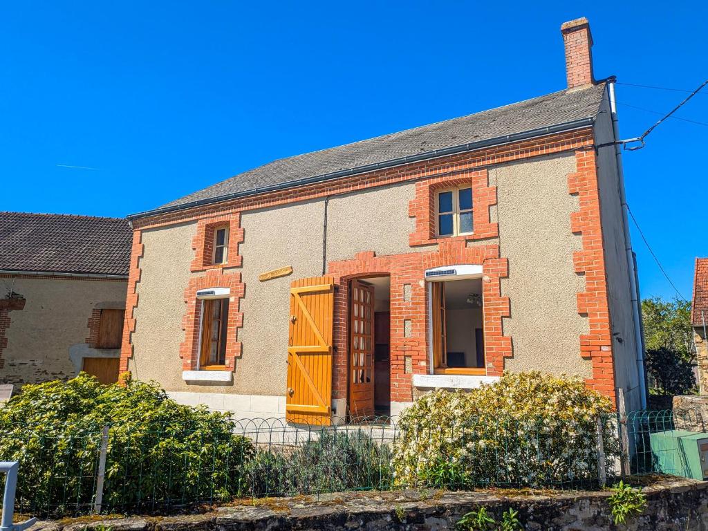 an old brick house with a yellow door at Maison avec parking - 7 pers. - FR-1-591-784 in Éguzon-Chantôme
