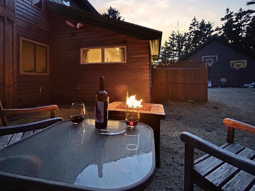 a table with a bottle of wine and two glasses at Quietside Studio - Fire Pit - Near Acadia in Southwest Harbor