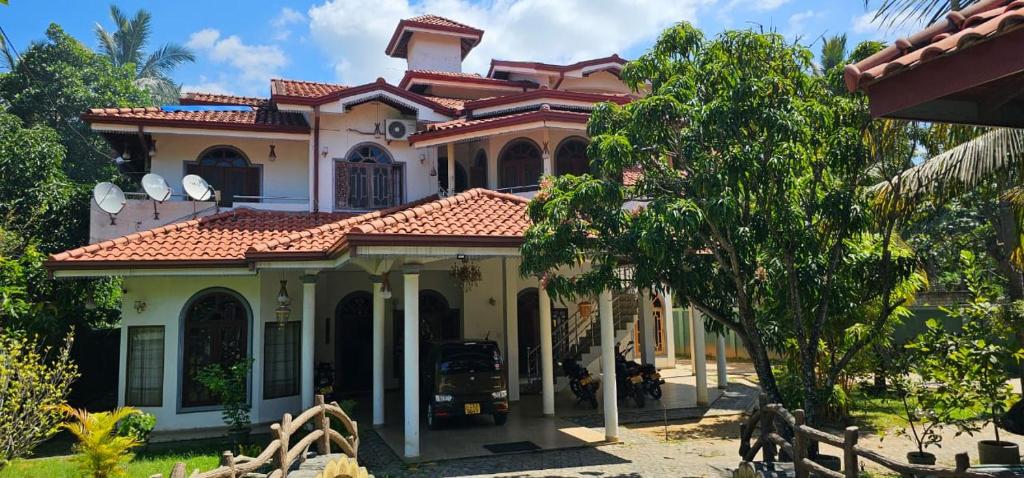 a large house with a red roof at Winter Palace Lakeside in Embilipitiya