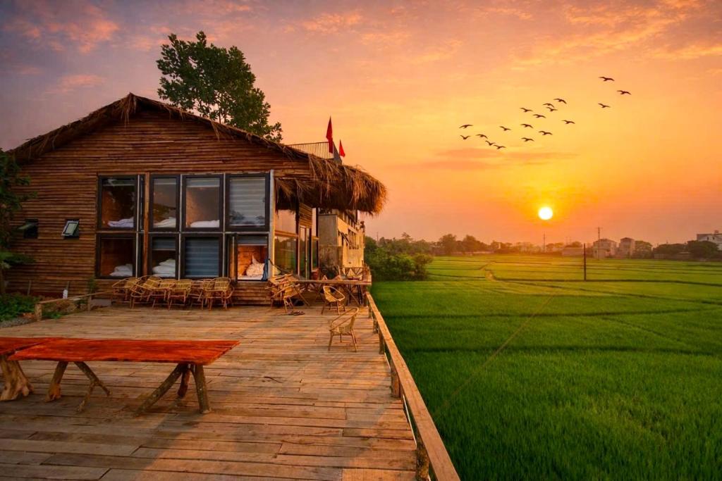 a group of birds flying in the sky over a house at A Thía homestay in Diện Biên Phủ