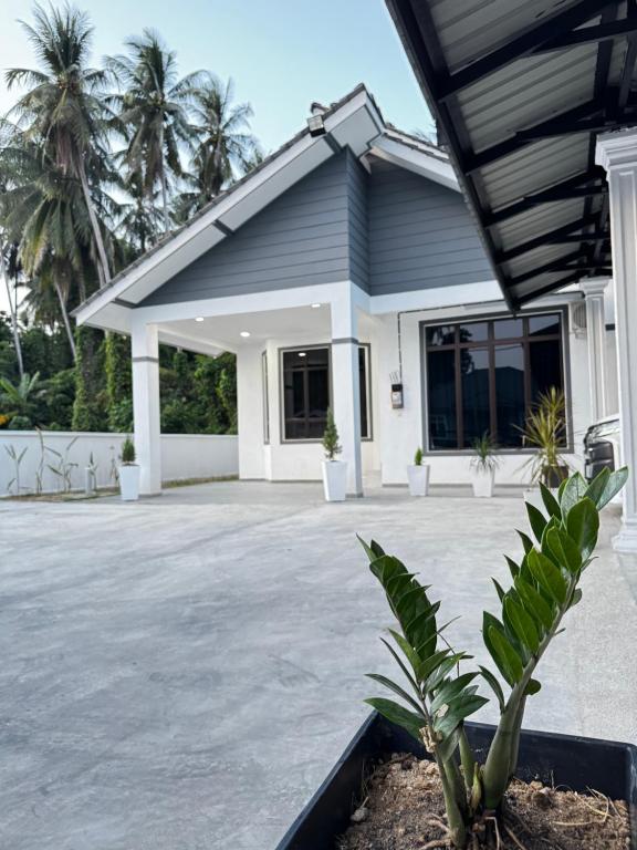 a house with a courtyard and palm trees at NY VILLA Homestay in Kota Bharu