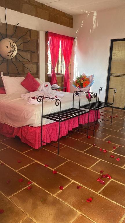 a bedroom with a bed with red rose petals on the floor at Wellness Pet Friendly El Secreto in Tepoztlán