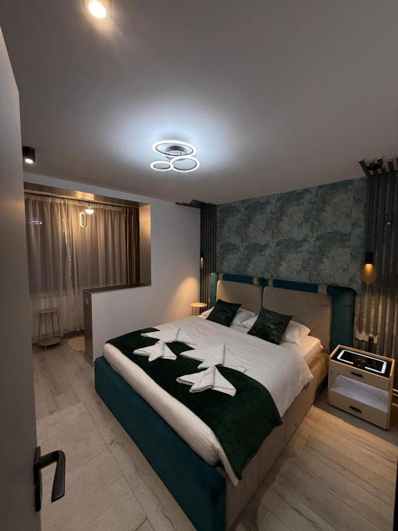 a bedroom with a large bed with a black and white blanket at Apartament André in Sibiu