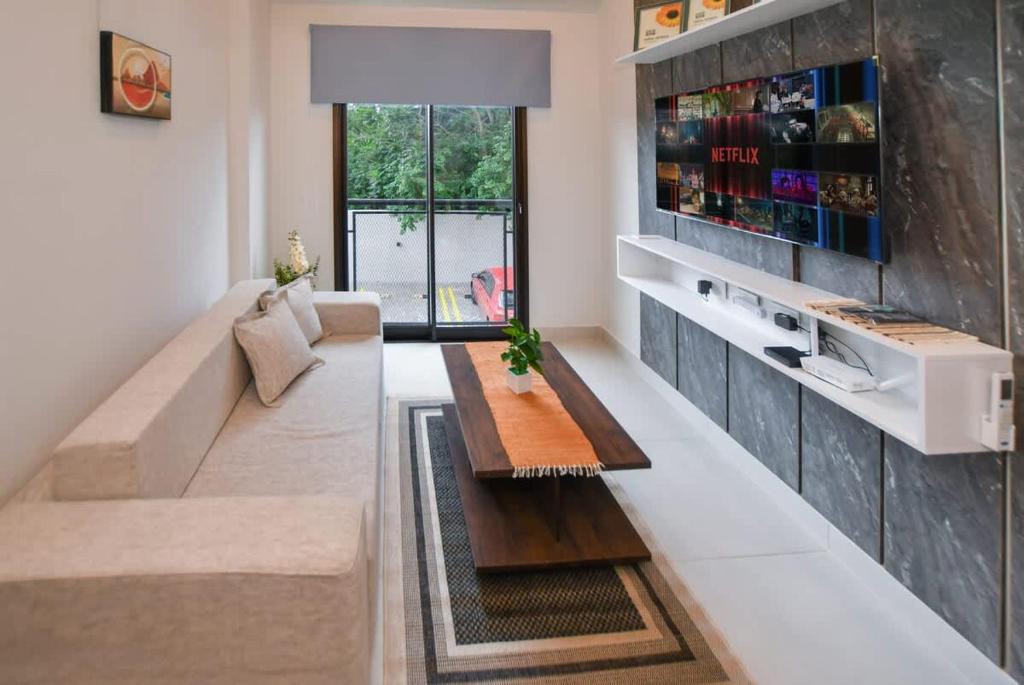 a living room with a couch and a table at Cozy 1BR Desk Pool & Terrace in Fernando de la Mora