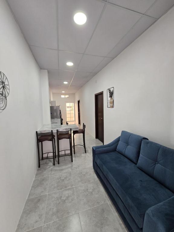 a living room with a blue couch and a table at Hammerhead Shark Apartment in Puerto Baquerizo Moreno