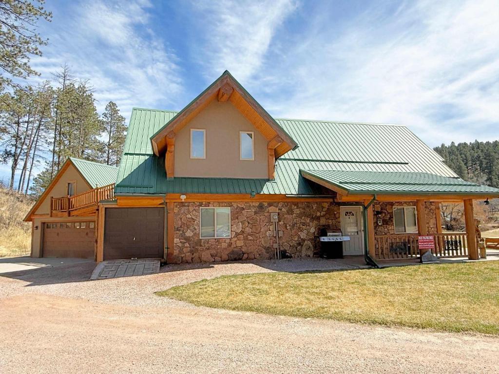 a house with a green roof and a garage at Cottage at Storm Mountain #3 in Hill City