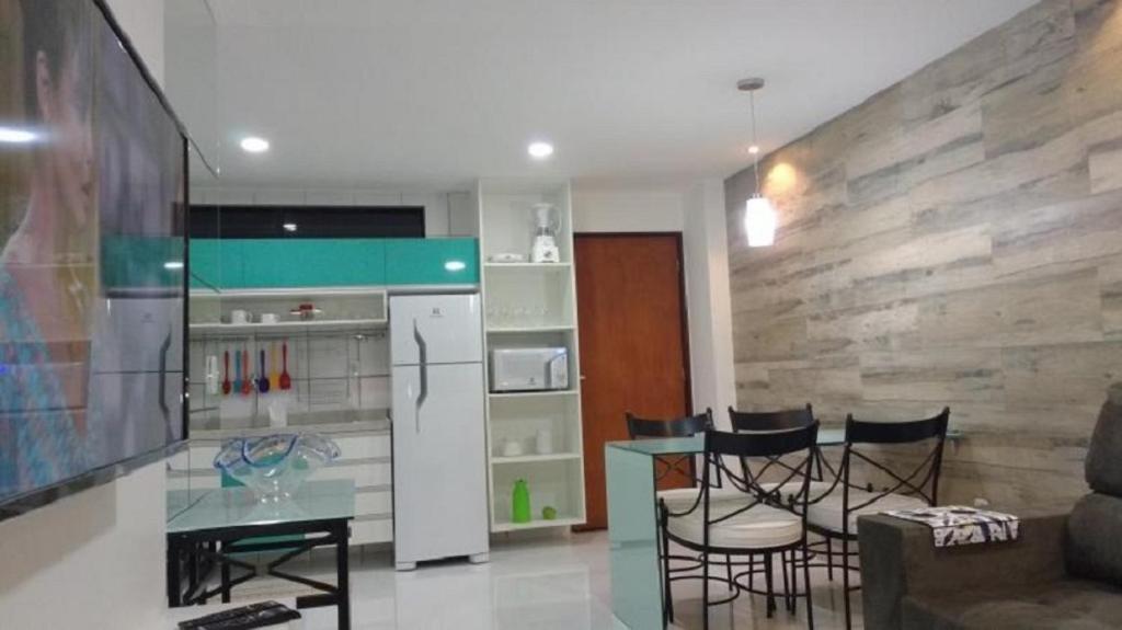 eine Küche mit einem Kühlschrank sowie einem Tisch und Stühlen in der Unterkunft Apartamento Vernazza in Maceió