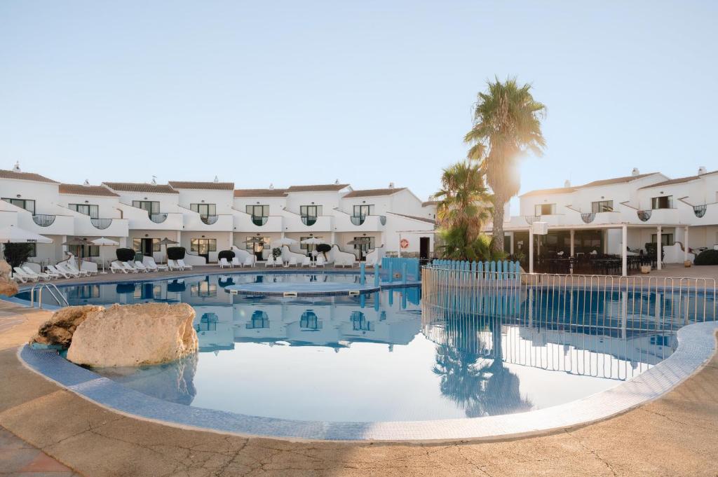 a swimming pool in front of a hotel at BLUESEA Lentiscos in Cala en Blanes