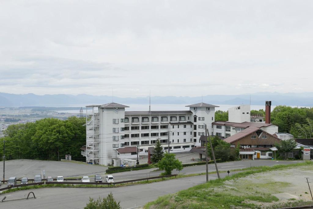 a large white building with a parking lot in front of it at Villa Inawashiro in Inawashiro