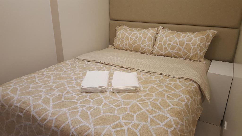 a bed with two white towels on top of it at Suntrust Parkview Apartment in Manila