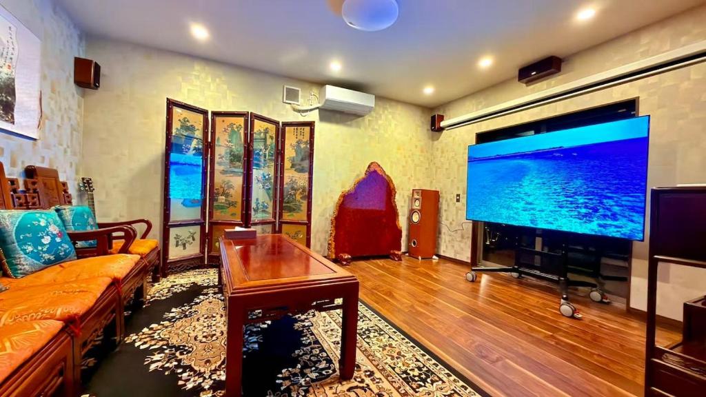 a living room with a large flat screen tv at House KIMIJIMA in Yachimata