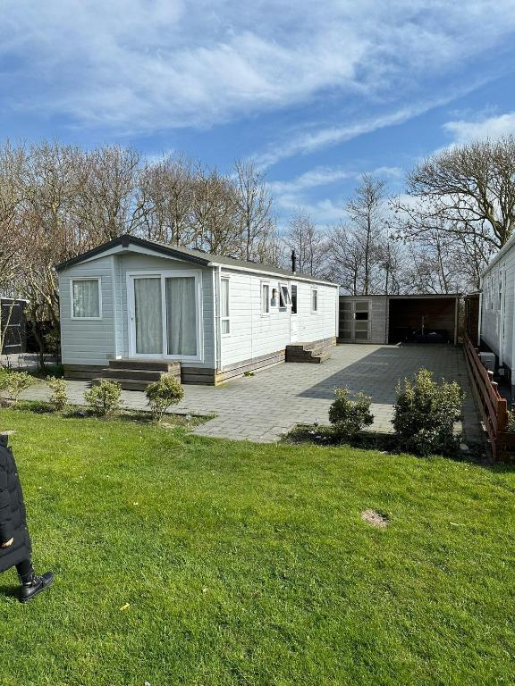a house with a garage and a yard at Chalet Vida in Petten