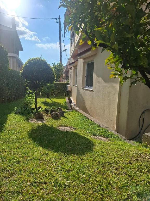 a yard with a house and a tree in the grass at "Alsos View" in Agrinio