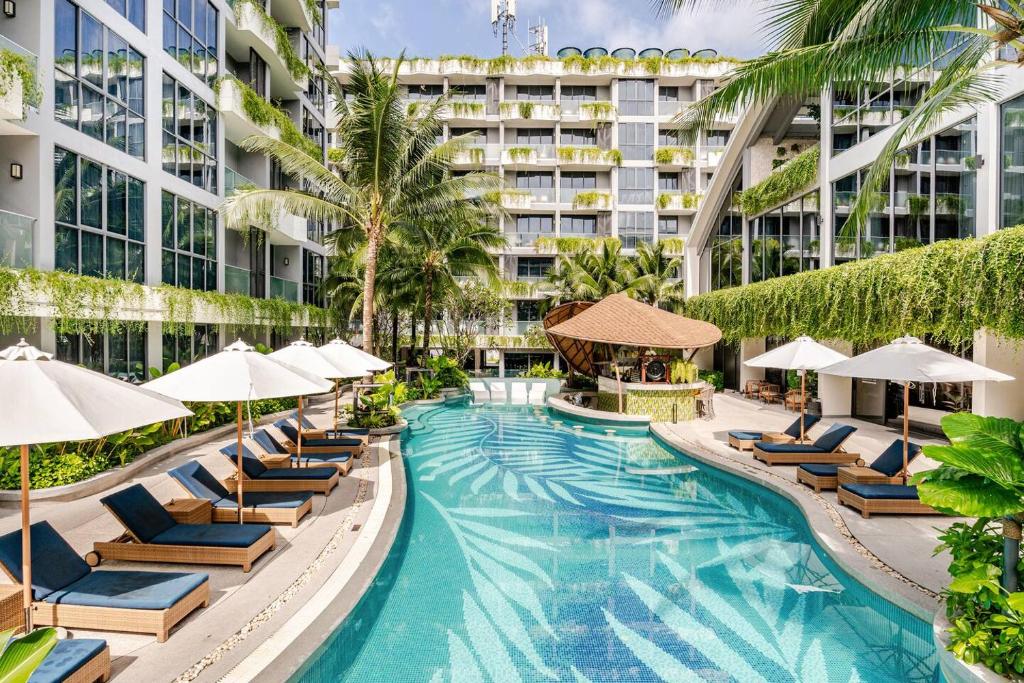 an image of a resort pool with lounge chairs and umbrellas at GreenLa by Villacarte in Layan Beach
