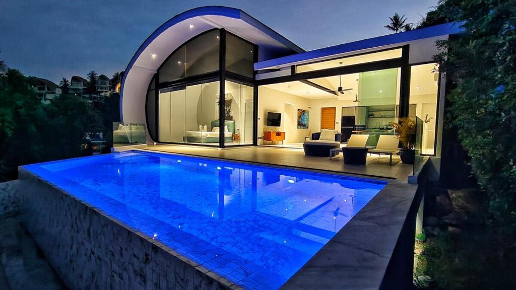 a large swimming pool in front of a house at Villa Lumina, Koh Samui in Chaweng Noi Beach