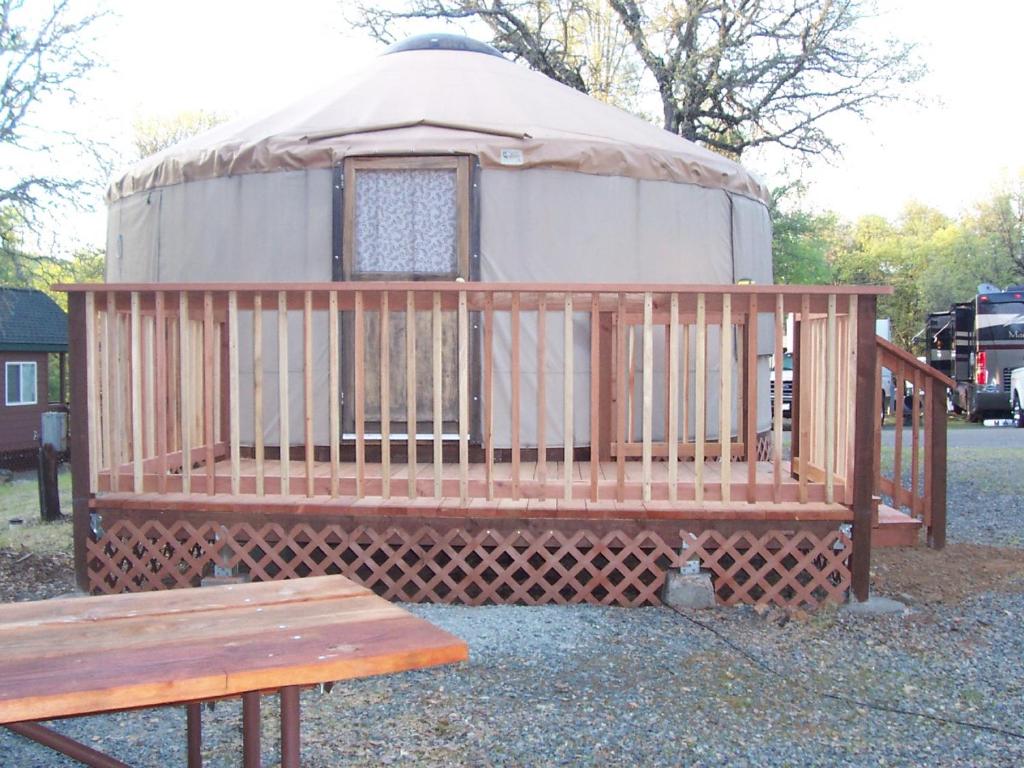 a yurt with a wooden bench and a wooden table at Lake of the Springs Camping Resort Yurt 6 in Oregon House