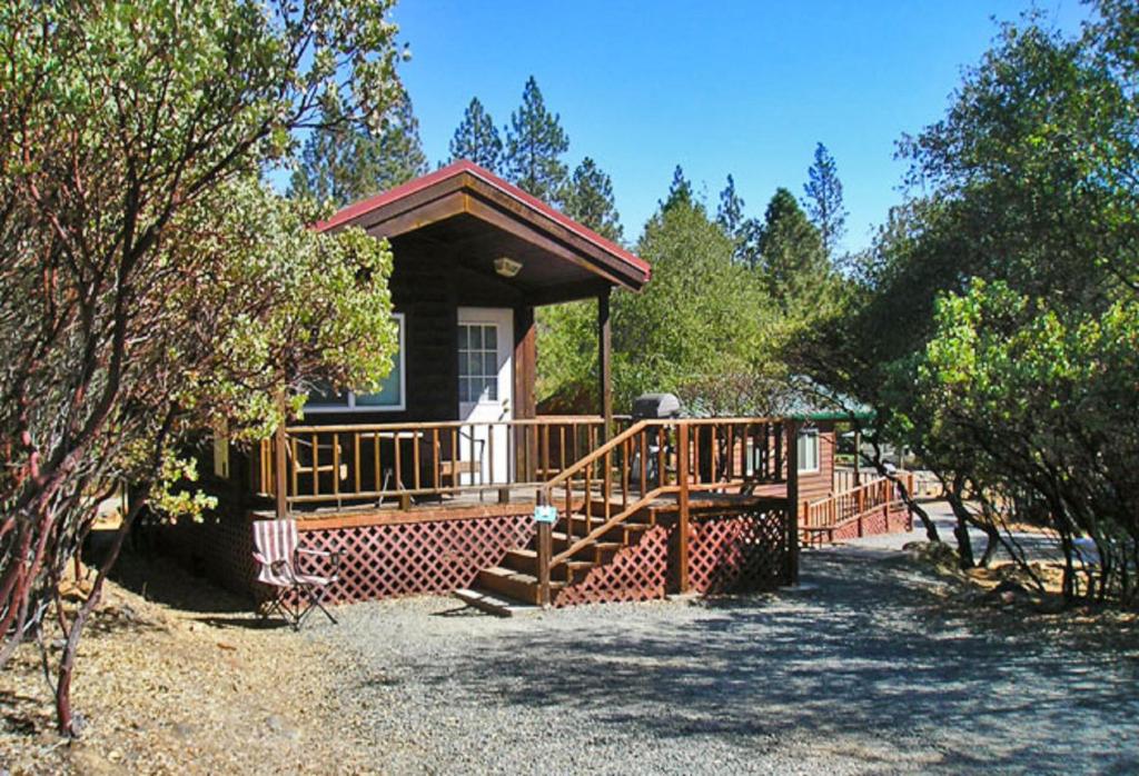 a small house with a large wooden deck at Lake of the Springs Camping Resort Cabin 1 in Oregon House