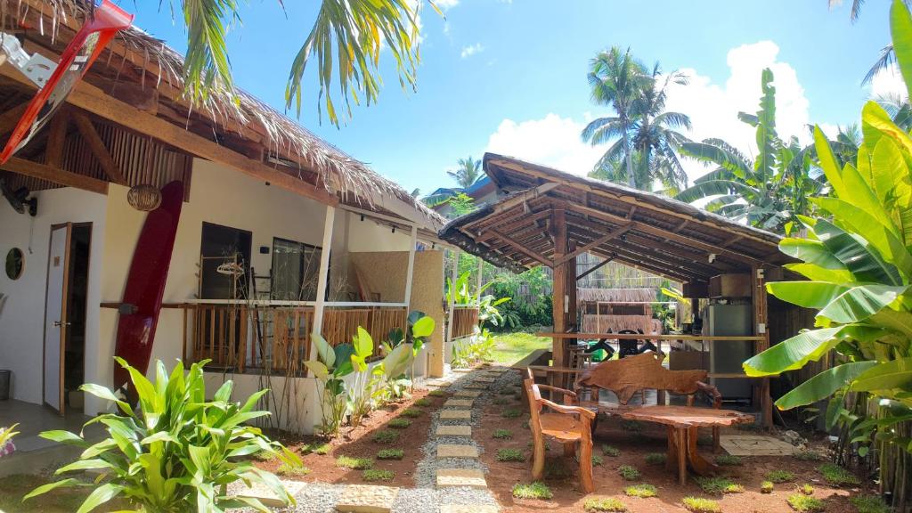 a house with a table and chairs in front of it at Bom Dia Siargao Villas in General Luna
