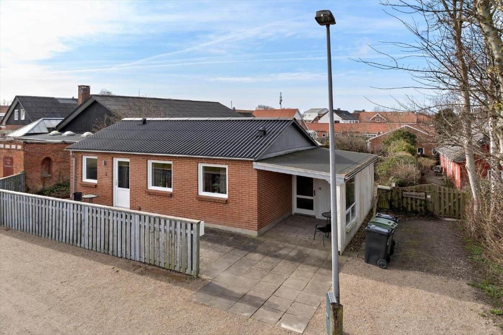 a red brick house with a black roof at LF10243-Thyholm-Krumborgvej-3 in Hvidbjerg