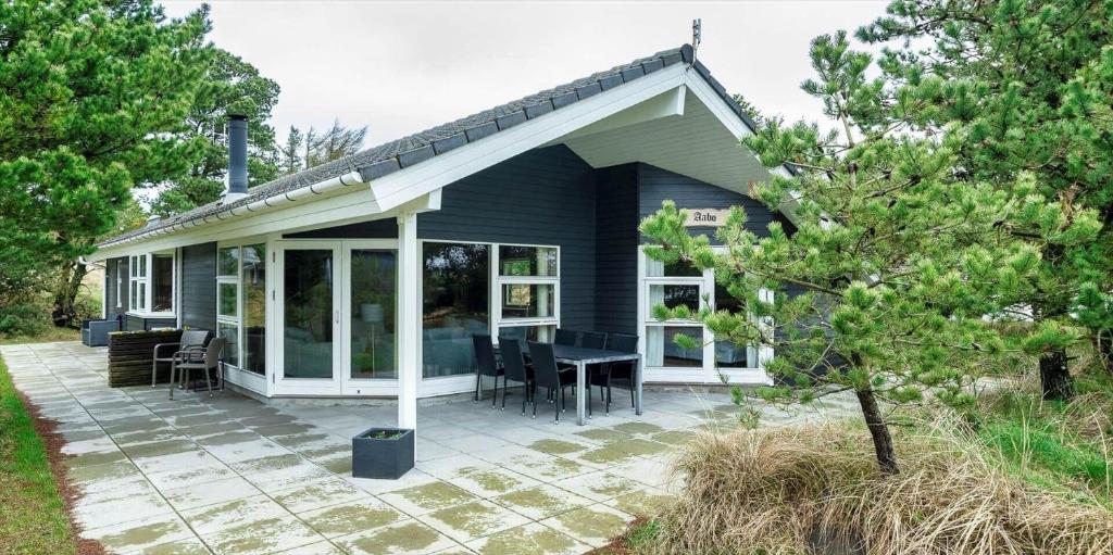 a blue house with a patio with a table at VE125-Vejers-Strand-Aavej-19 in Vejers Strand