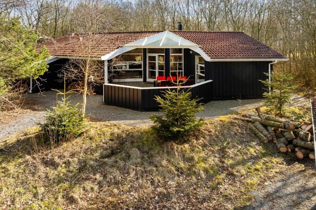 a small black house with a white roof at LF12022-Spottrup-Skovmarken-2 in Vadum