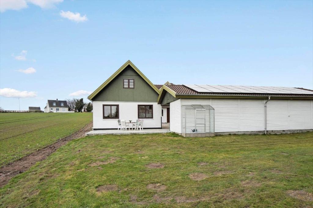 a white house with a green roof and a field at FY410-Faaborg-Mosetoften-10-B in Diernæs