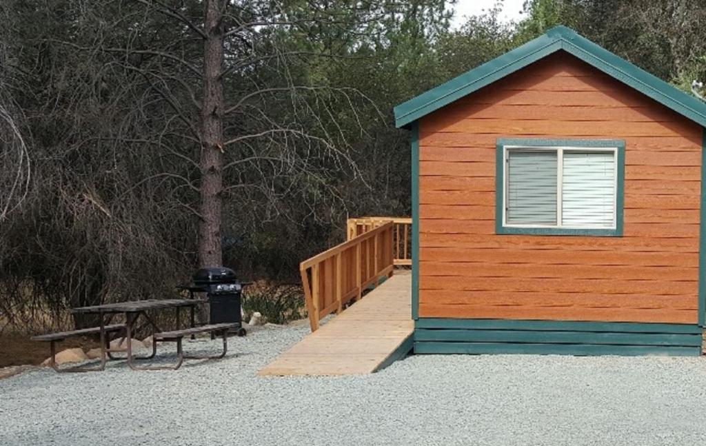 a small building with a picnic table and a bench at Lake of the Springs Camping Resort Cottage 7 in Oregon House